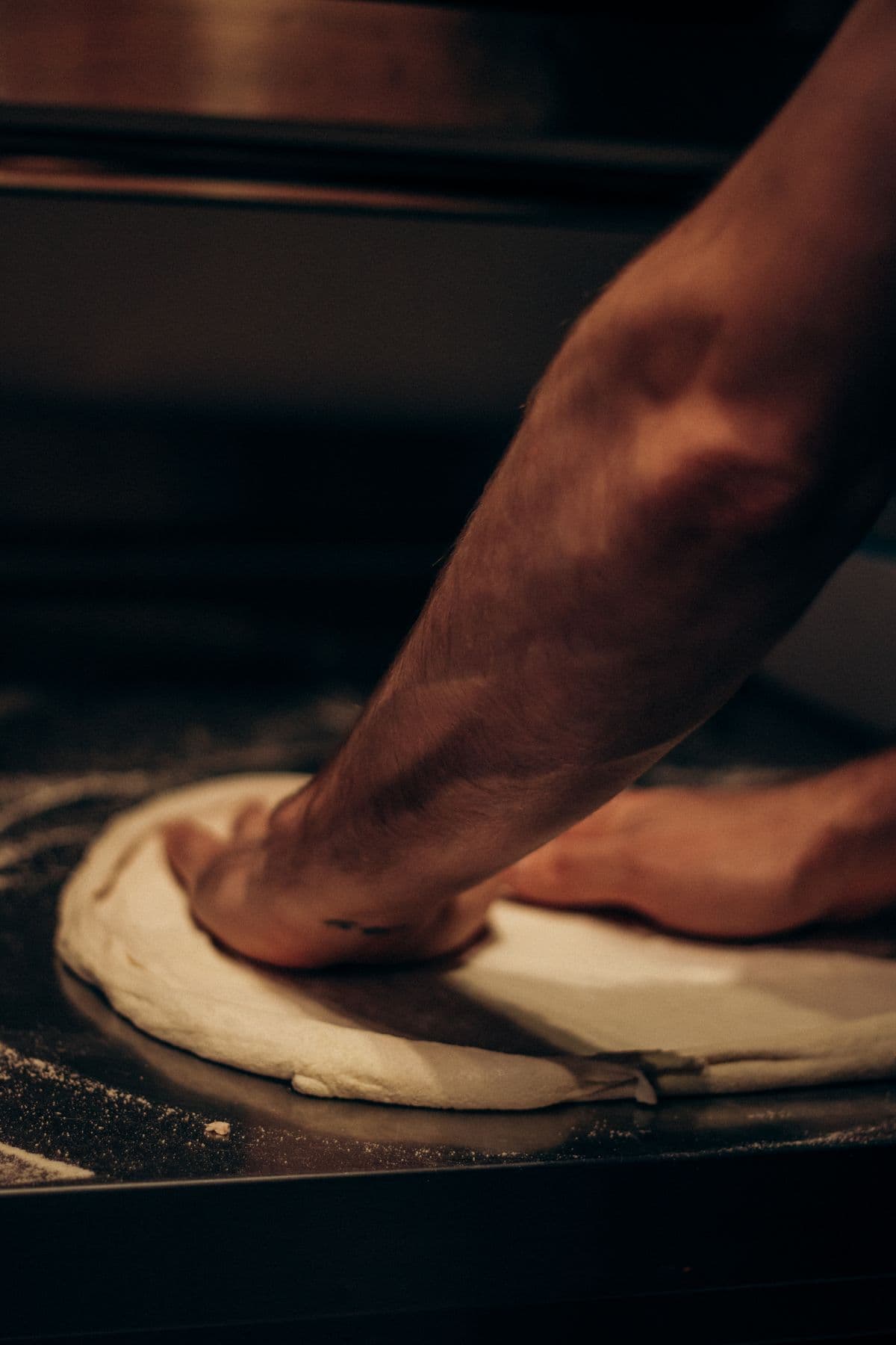 Pizzaïolo travaillant la pâte à la main chez Pizza Sun